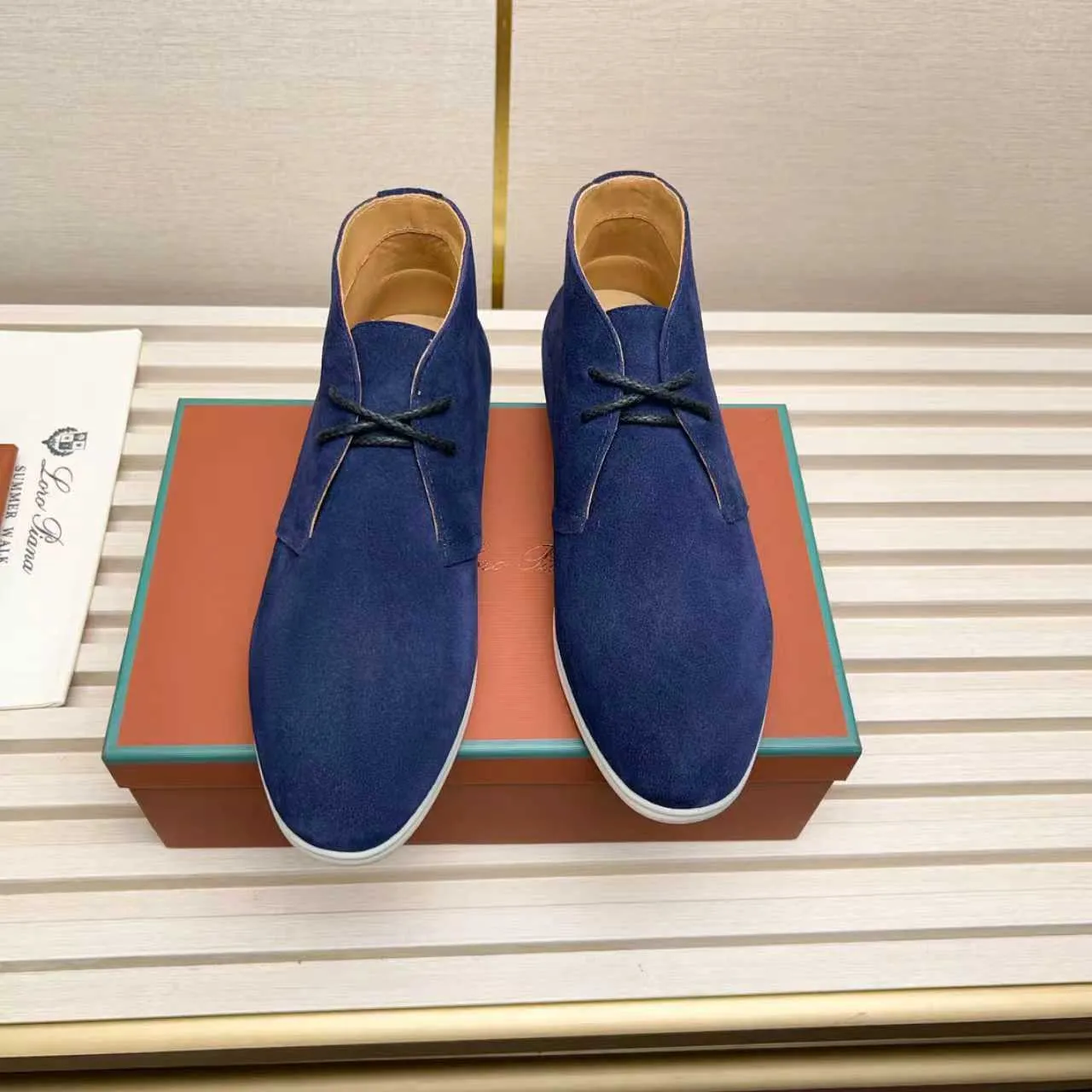 Men's Shoes 💰420 Loro Piana reimagines the desert boot—a modern, comfortable interpretation of a classic 1940s style. Crafted from suede calfskin, it exudes elegance. The tight texture of suede calfskin is not only durable but also looks casual and sophisticated. Add a timeless piece to your shoe collection, harmoniously blending comfort, style and Loro Piana's heritage of craftsmanship. Acetate satin detail on the inside White sole with LP lettering for added traction Space for a personalized signature on the heel Tonal suede trim Upper: 100% cow split suede Sole: 100% Rubber lining: Cow leather